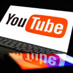 YouTube logo on a laptop and smartphone screen.