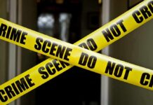 Yellow crime scene tape crossing a doorway