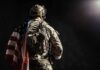 Bipartisan Push Targets Cruel Widow Rule Soldier in tactical gear with American flag over shoulder
