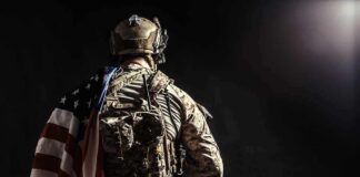 Soldier in tactical gear with American flag over shoulder