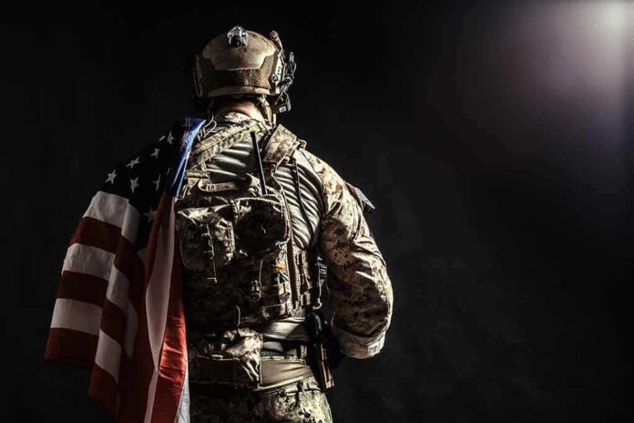 Soldier in tactical gear with American flag over shoulder