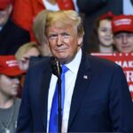 man in suit at rally podium