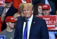 man in suit at rally podium