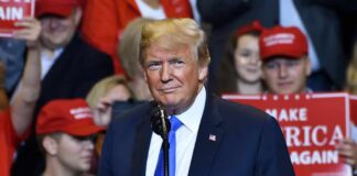 man in suit at rally podium