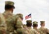 Shortage Scare Flipped: Trump Fires Back U.S. flag flying above a formation of soldiers in uniform