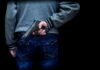 person holding a handgun behind their back