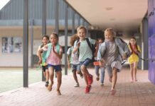 Children running through a school hallway with backpacks