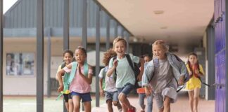 Children running through a school hallway with backpacks