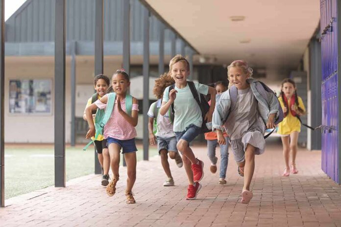 Children running through a school hallway with backpacks
