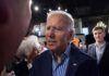 Hunter’s Bombshell: Cancer Goes Further man in suit interacting with people at an indoor event
