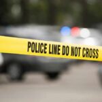 Yellow police line tape at a blurred street scene