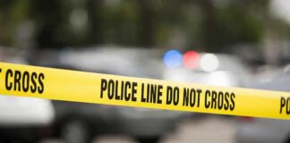 Yellow police line tape at a blurred street scene