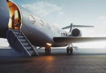 Private jet on tarmac with open door and stairs