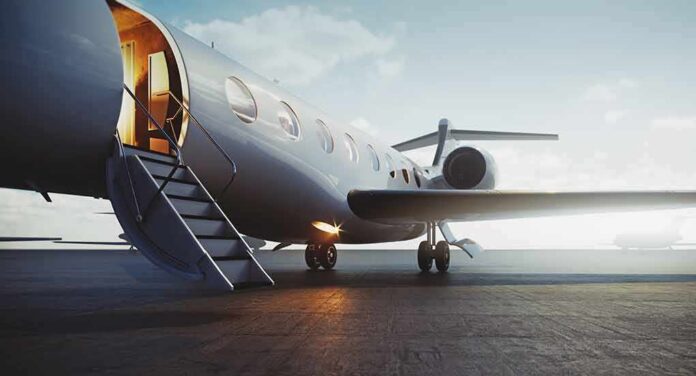 Private jet on tarmac with open door and stairs
