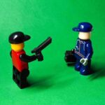two lego minifigures facing each other on a green background