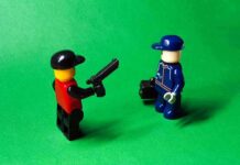 College Kid Outsmarts Loans With LEGO two lego minifigures facing each other on a green background