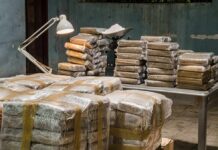 Stacks of wrapped packages on tables in a dim room