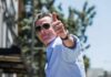 man in sunglasses giving a thumbs-up outdoors