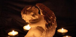 Drug Den Baby Death Sparks No-Bail Push angel statue surrounded by lit candles