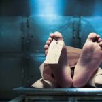 Corpse on a morgue table with toe tag