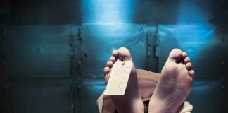 Corpse on a morgue table with toe tag