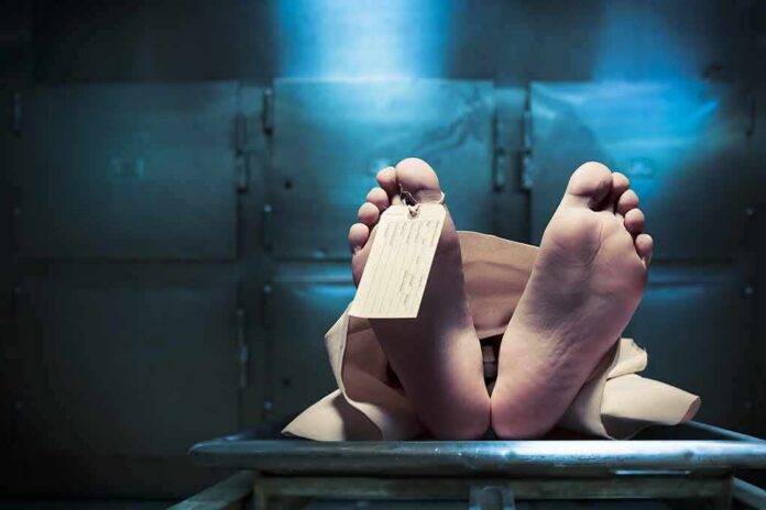 Corpse on a morgue table with toe tag