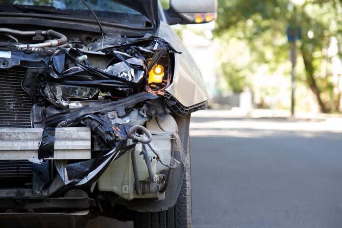 shutterstock_1927978676 Front of a car with severe collision damage and exposed headlight