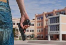 Person holding a handgun near a school building