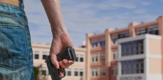Person holding a handgun near a school building