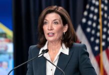 woman speaking at a podium with microphones