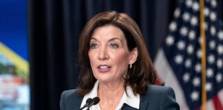 woman speaking at a podium with microphones