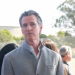 Newsom’s Michigan Gamble Backfires—What Did He Unleash? man in gray coat at an outdoor event