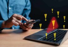 Fake 49er Lures Victims Into Costly Trap Person using smartphone near laptop with warning icons
