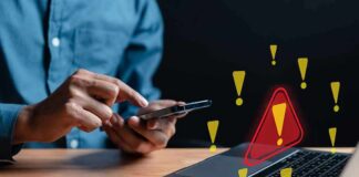 Fake 49er Lures Victims Into Costly Trap Person using smartphone near laptop with warning icons