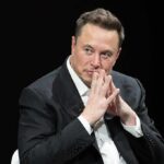 man in a suit with hands clasped thoughtfully