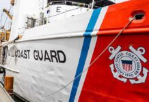 US Coast Guard ship hull with emblem and red stripe