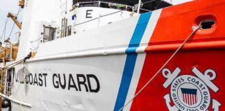 US Coast Guard ship hull with emblem and red stripe