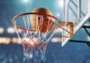 Basketball swishing through hoop in stadium