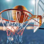Basketball swishing through hoop in stadium