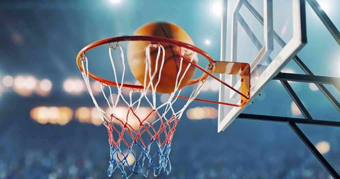 Basketball swishing through hoop in stadium