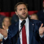Man in suit speaking at a podium