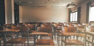 Empty classroom with rows of wooden desks and chairs