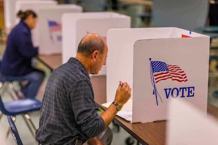 Man filling out ballot at voting booth