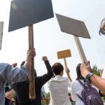 Group of people holding protest signs outdoors