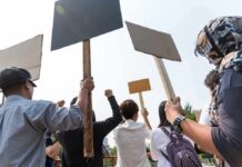 Group of people holding protest signs outdoors