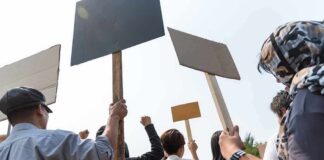 Group of people holding protest signs outdoors