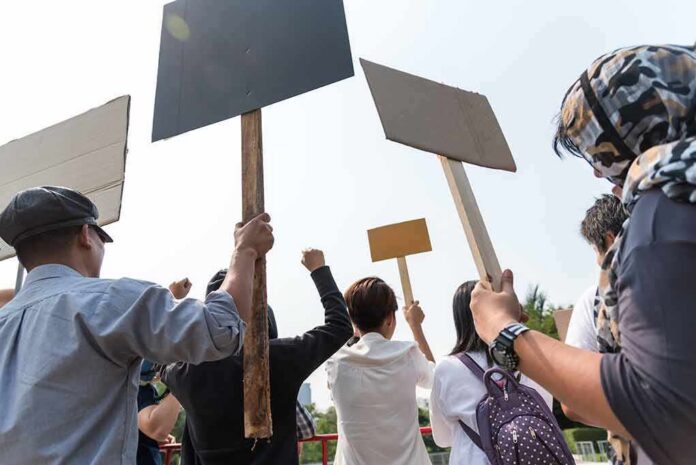 Group of people holding protest signs outdoors