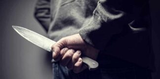 person holding a large knife behind their back