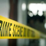 crime scene tape in a blurred indoor setting