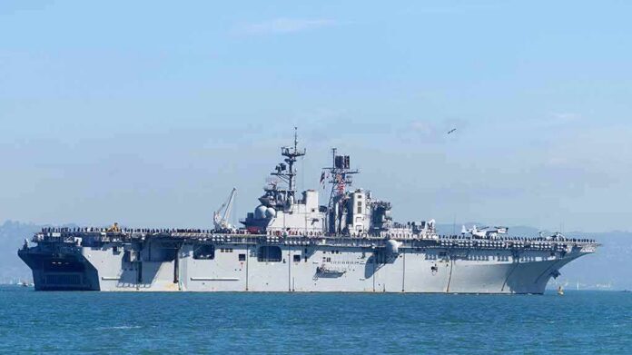 shutterstock_1196717440 Aircraft carrier sailing on calm blue water